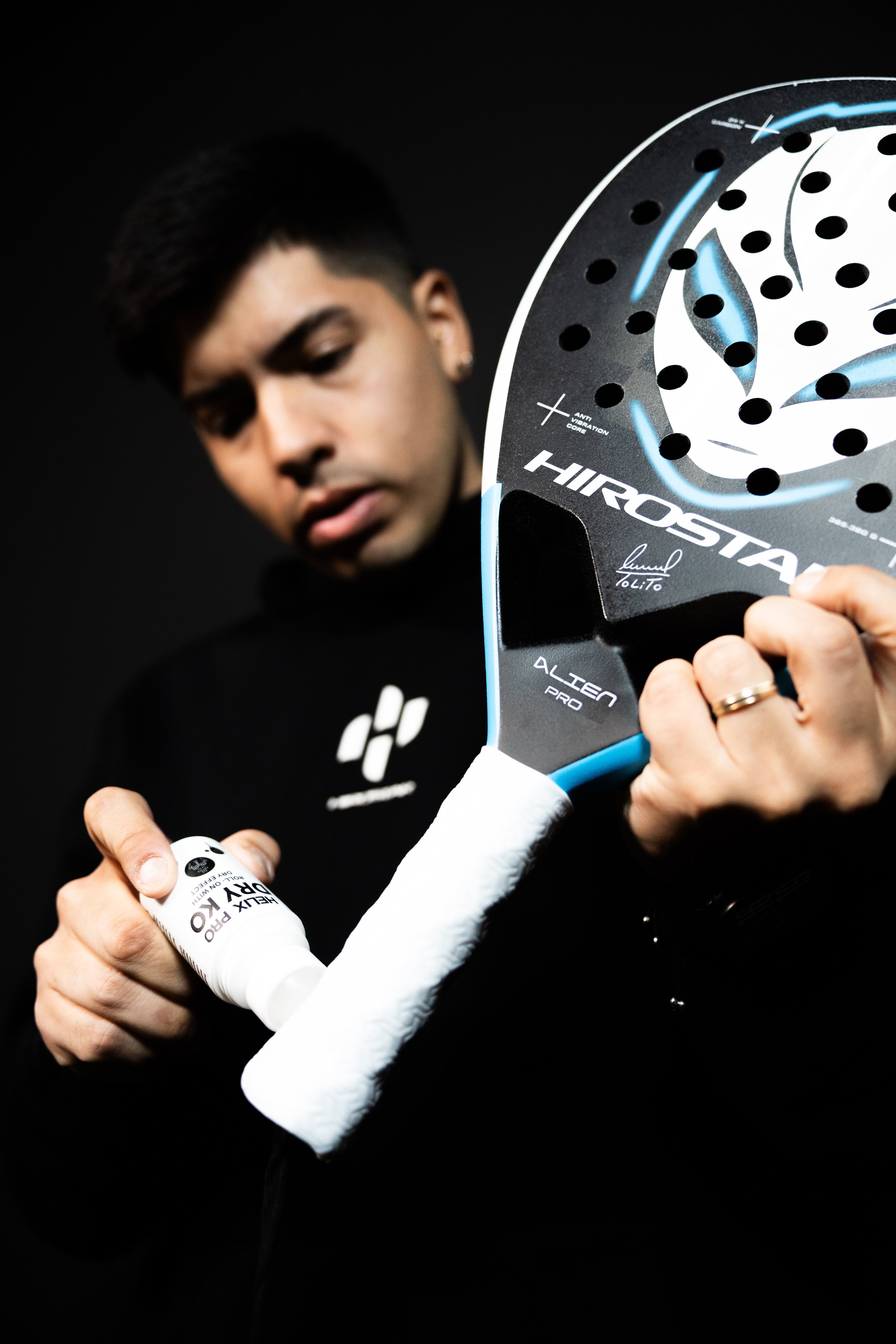 Tolito Aguirre aplicando el roll-on de agarre Helix Pro sobre el grip de pádel